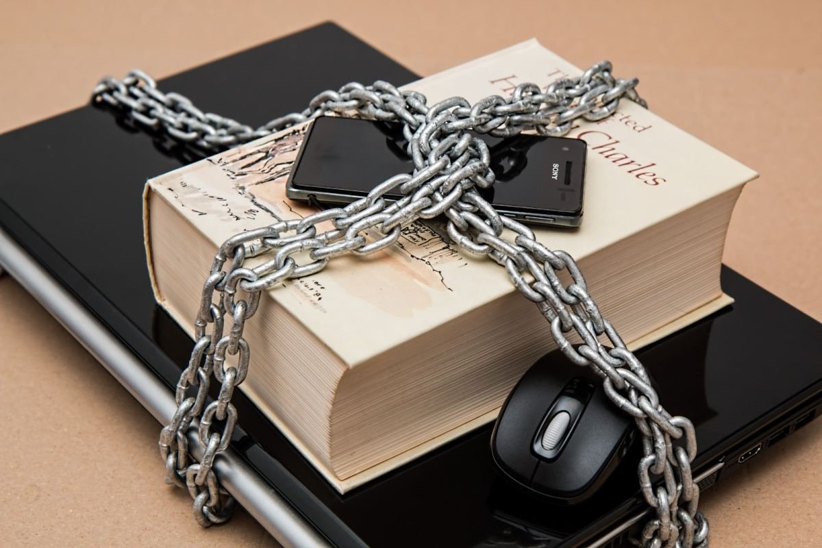 A laptop, phone and documents secured together, representing locked-down personal data